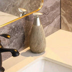 Decorative bottle on a bathroom counter with marble wall and mirror in the background