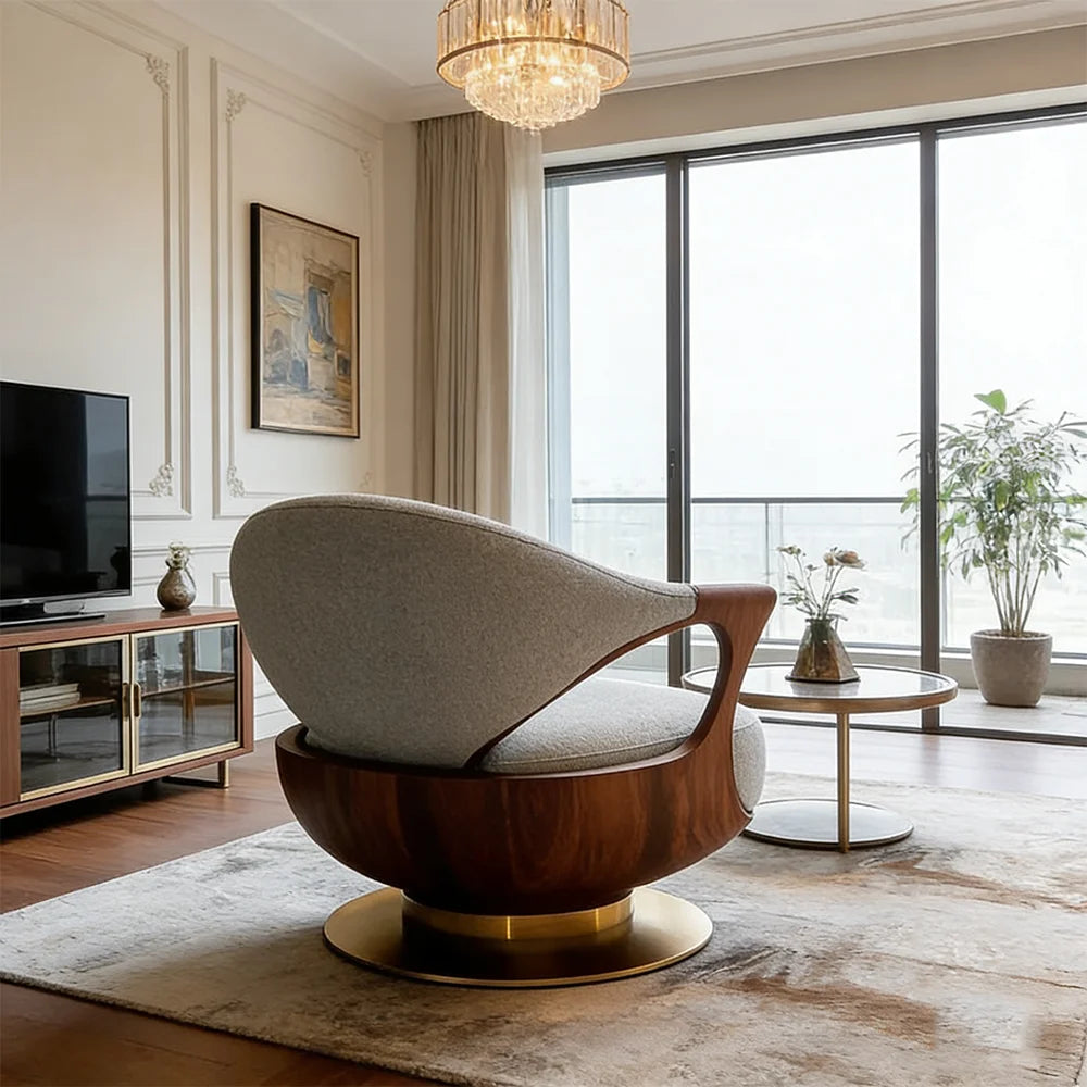 Modern living room with a stylish armchair, television, and large windows.