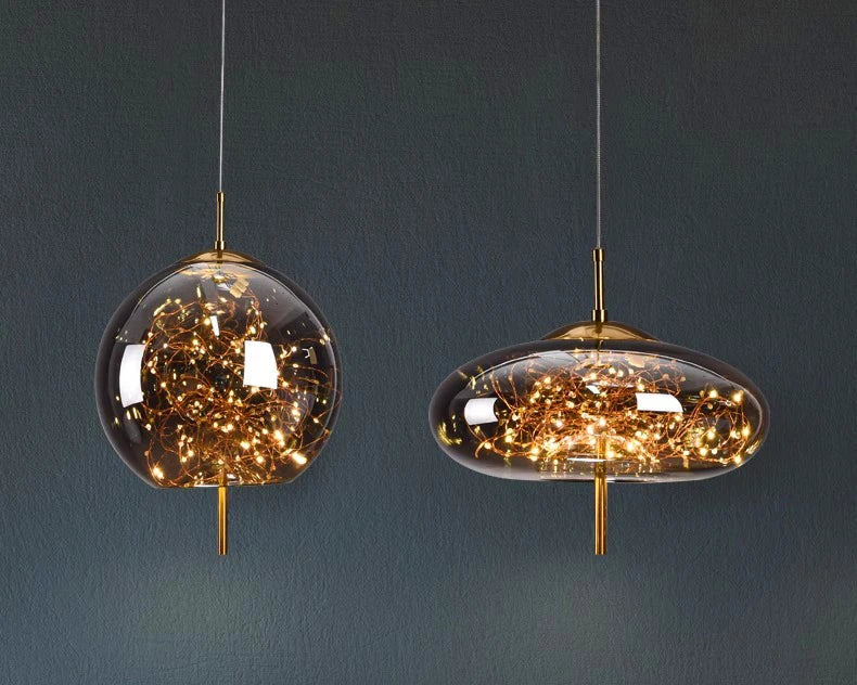 Modern pendant lights hanging above a desk with a computer monitor displaying 'Oahu'.