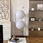 Modern interior with a floor lamp featuring two large white spherical shades.