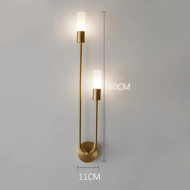 Gold wall sconce with dimensions indicated on a gray background