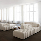 Modern beige sofa in a room with large windows and dark flooring