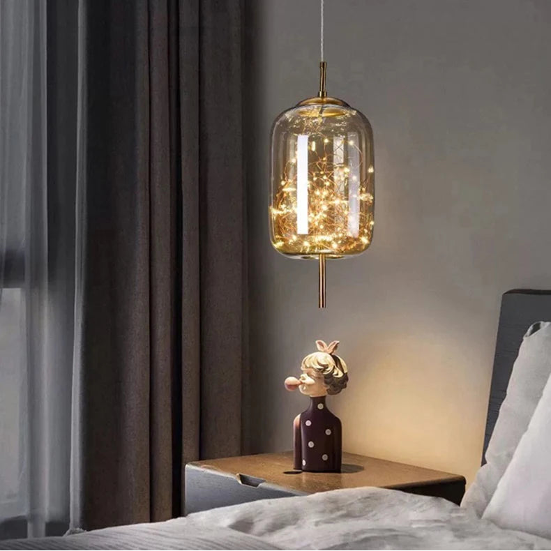 Modern pendant light hanging above a bed in a bedroom setting