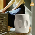 Person sitting on a textured stool with a weight limit indicator in the corner.