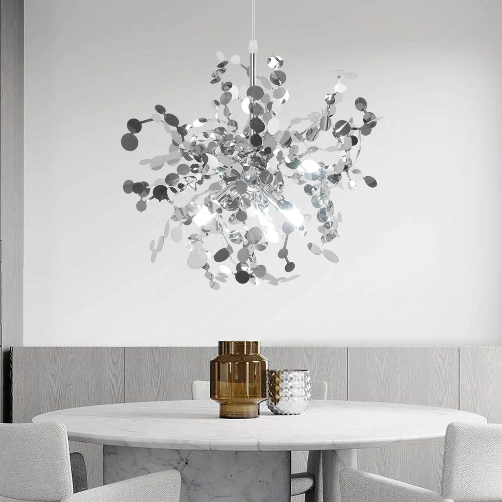 Modern chandelier hanging above a dining table with a neutral background