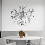 Modern chandelier hanging above a dining table with a neutral background