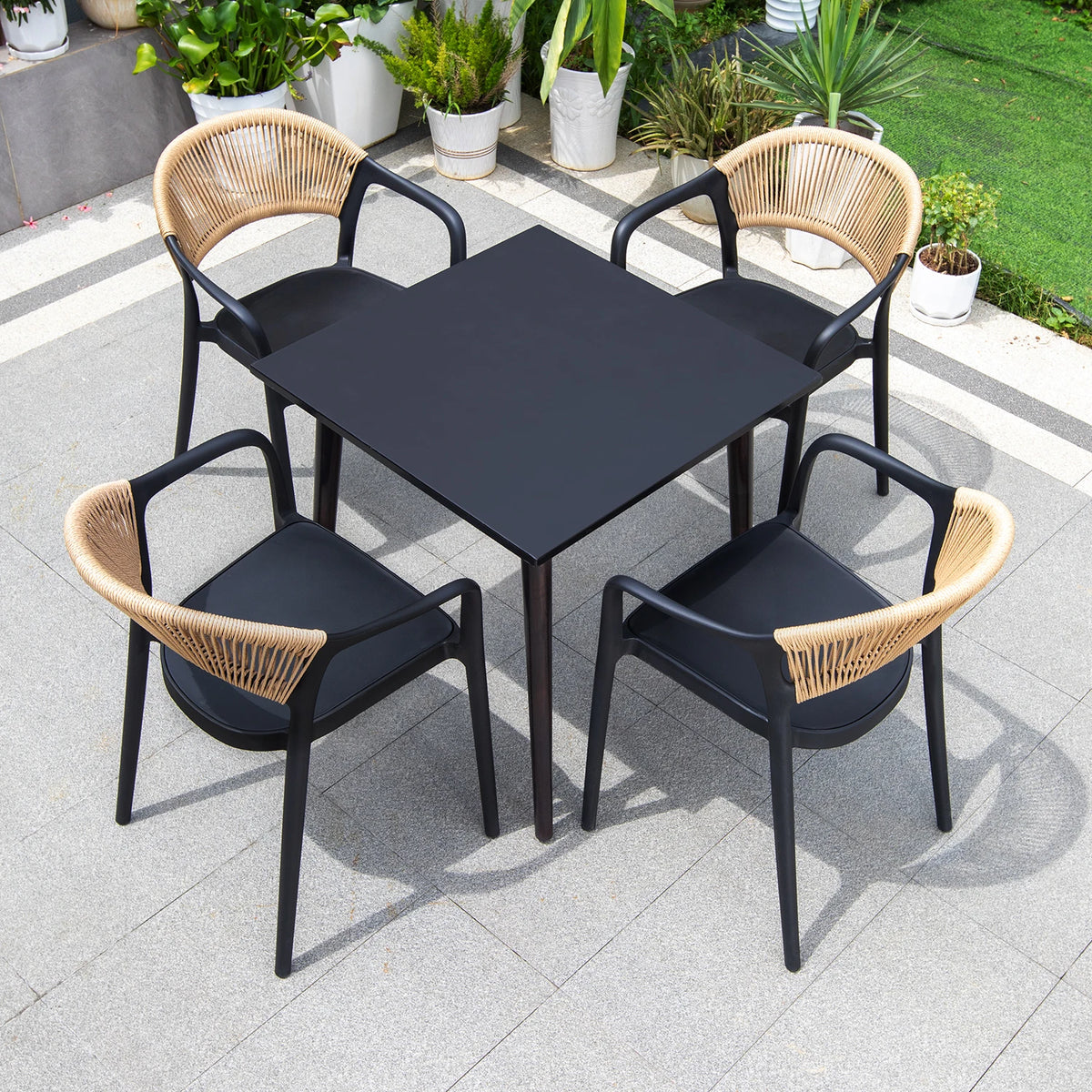 Black dining table with four chairs on a patio