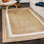 Woven jute rug with a white border in a living room setting.