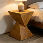 Concrete side table with a lamp next to a bed in a bedroom setting