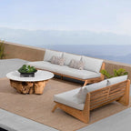 Outdoor furniture set with wooden chairs and a stone table on a patio with a scenic background.