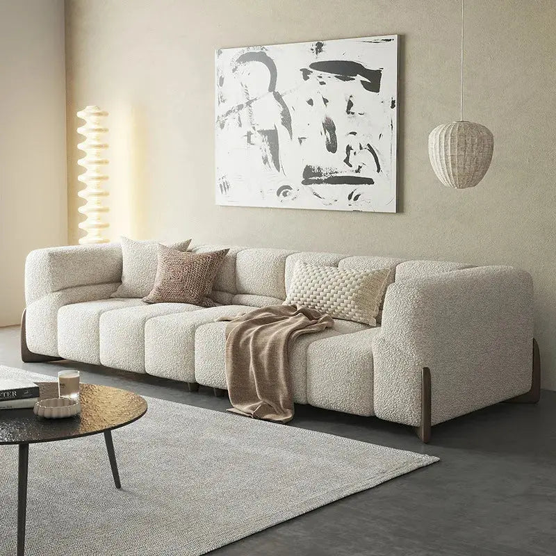 Modern living room with a beige sectional sofa, abstract art, and a round coffee table.