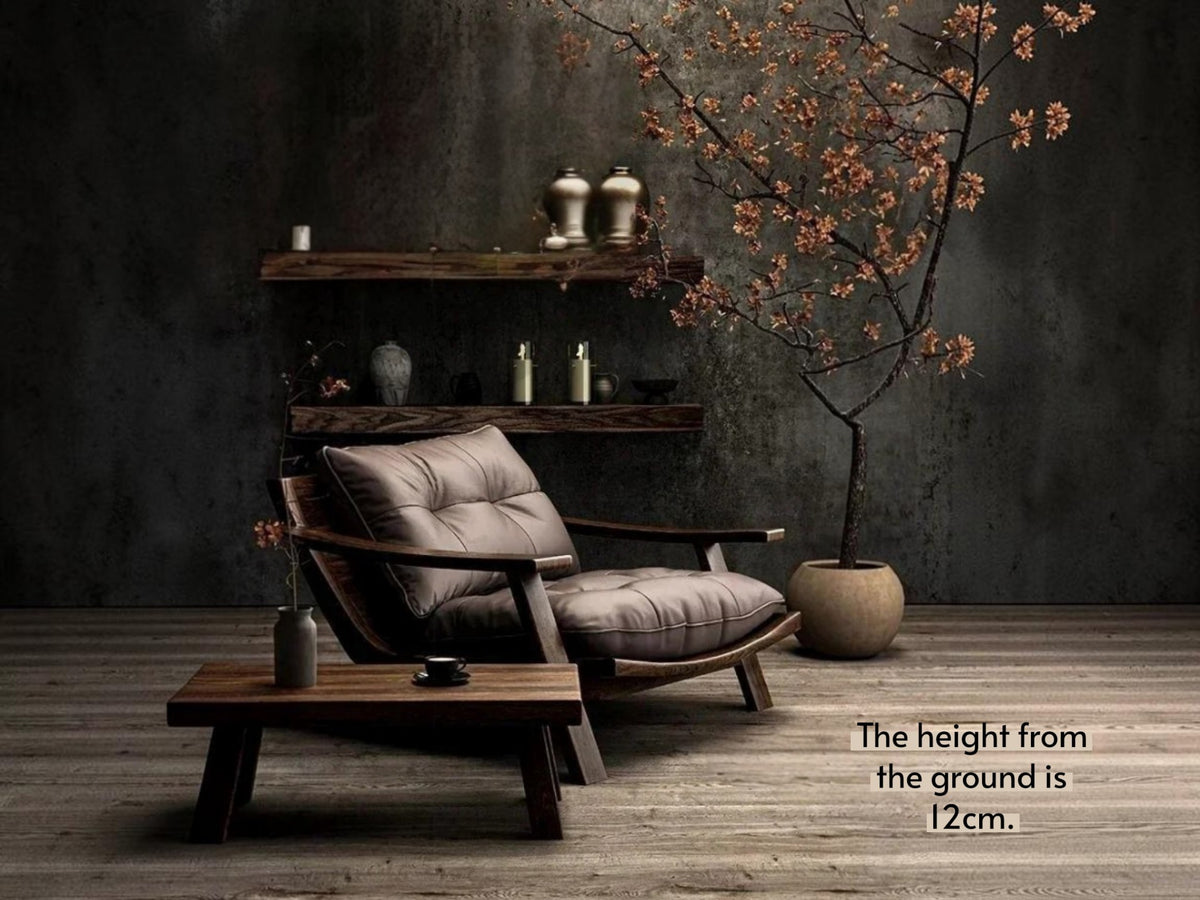 A mid-century modern lounge chair with tufted taupe cushions and dark wood arms, styled in a dark, atmospheric room with a wooden coffee table, floating shelves, and a potted tree. Text in the corner reads 'The height from the ground is 12cm.