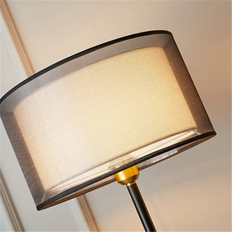 Floor lamp with a beige shade and black frame on a blurred background