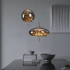 Two modern pendant lights with glass shades on a neutral background