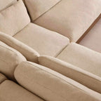 Close-up of a beige upholstered sectional sofa showing the textured fabric and clean lines of the cushions.