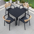 Black outdoor table with four matching chairs on a tiled patio