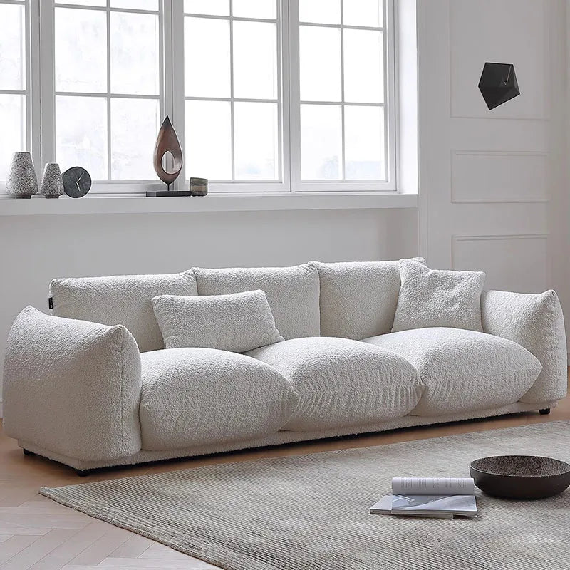 White sofa in a modern living room with large windows.