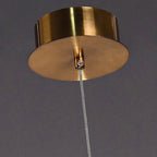 Gold pendant light fixture against a dark background