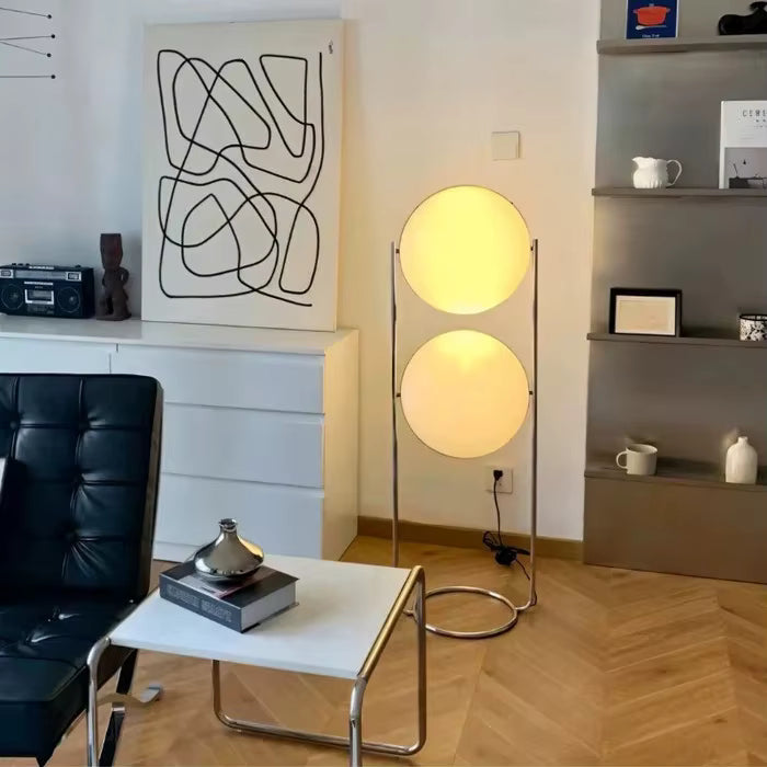Modern living room with a black leather chair, white table, and floor lamp.