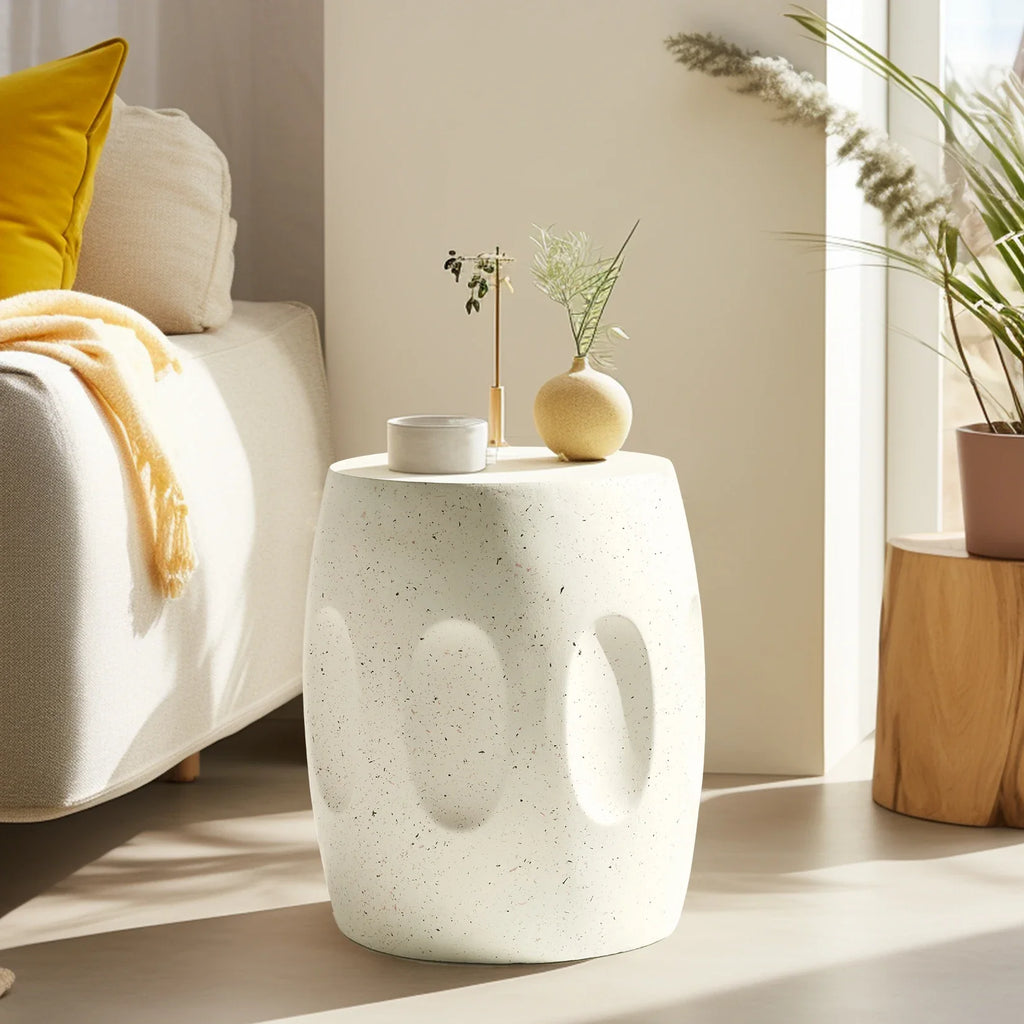 White textured side table with decorative items in a living room setting