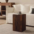 Wooden side table with a coffee cup on it, placed in front of a white sofa in a living room setting.