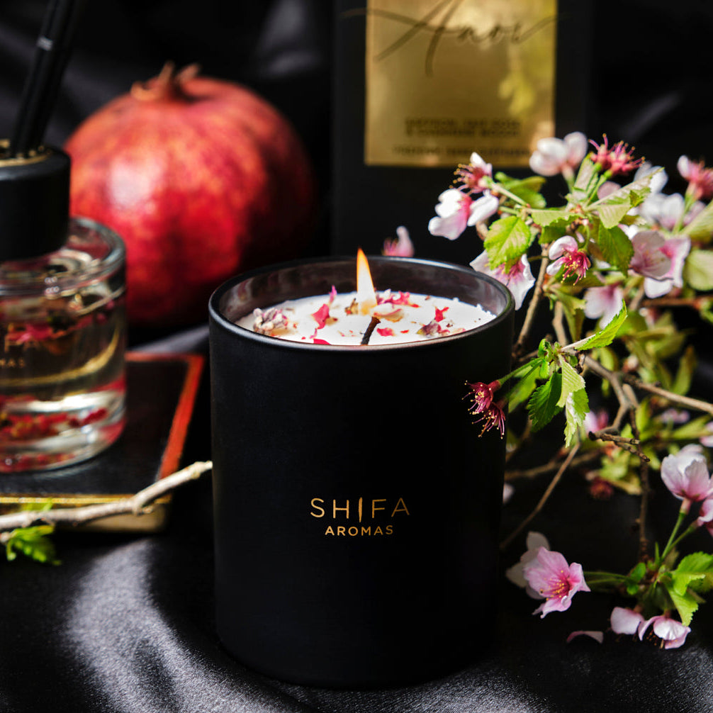 Shifa Aromas candle with flowers and pomegranate on a dark background