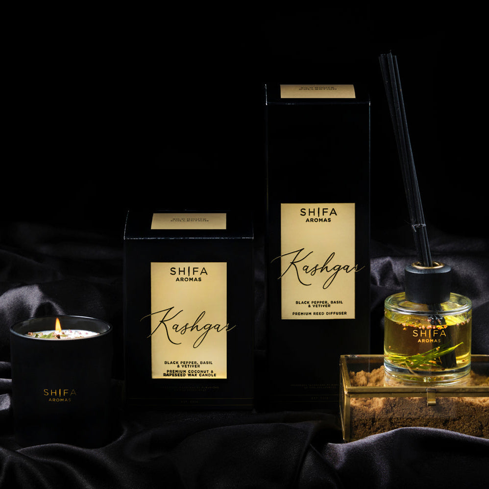 SHIFA Kashgar products including a candle, diffuser, and packaging on a dark fabric background