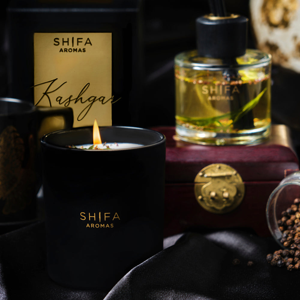 Shifa Aromas candles and diffuser with decorative elements on a dark background