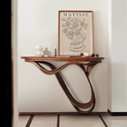 Wooden console table with a Matisse print on a wall in a room.