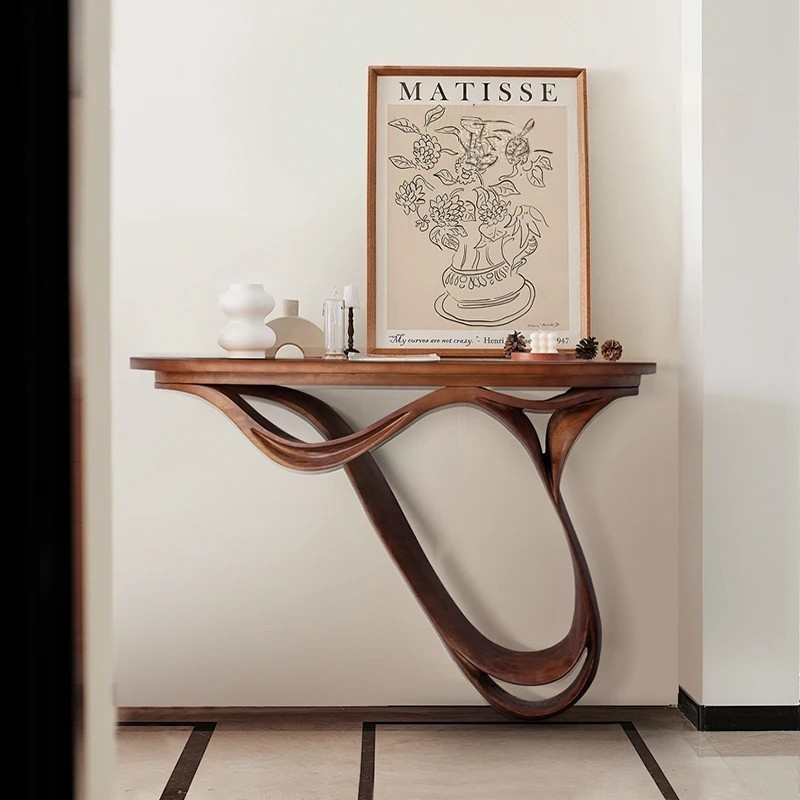 Wooden console table with a Matisse print on a wall in a room.