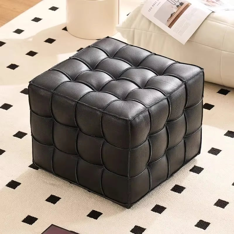Black leather ottoman on a patterned rug