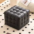 Black leather ottoman on a patterned rug
