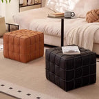 Two quilted ottomans, one brown and one black, in a living room setting.