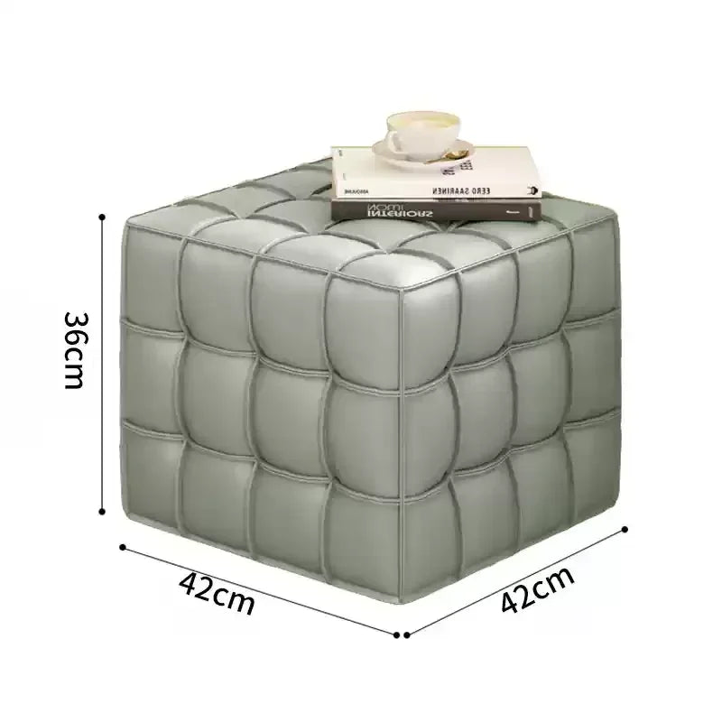 Gray cube-shaped ottoman with dimensions and a book on top