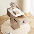 Modern side table with a drawer, decorative items, and a vase on a wooden floor.