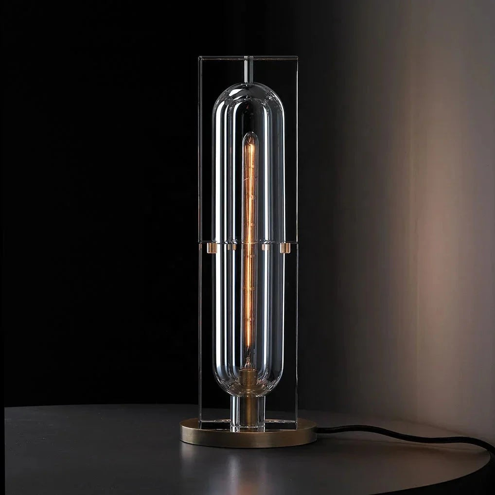 Modern table lamp with clear glass shade and visible bulb on a dark background