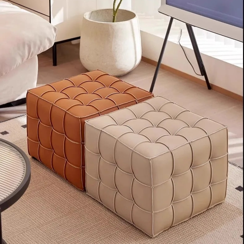 Two patterned ottomans in brown and beige on a carpeted floor.