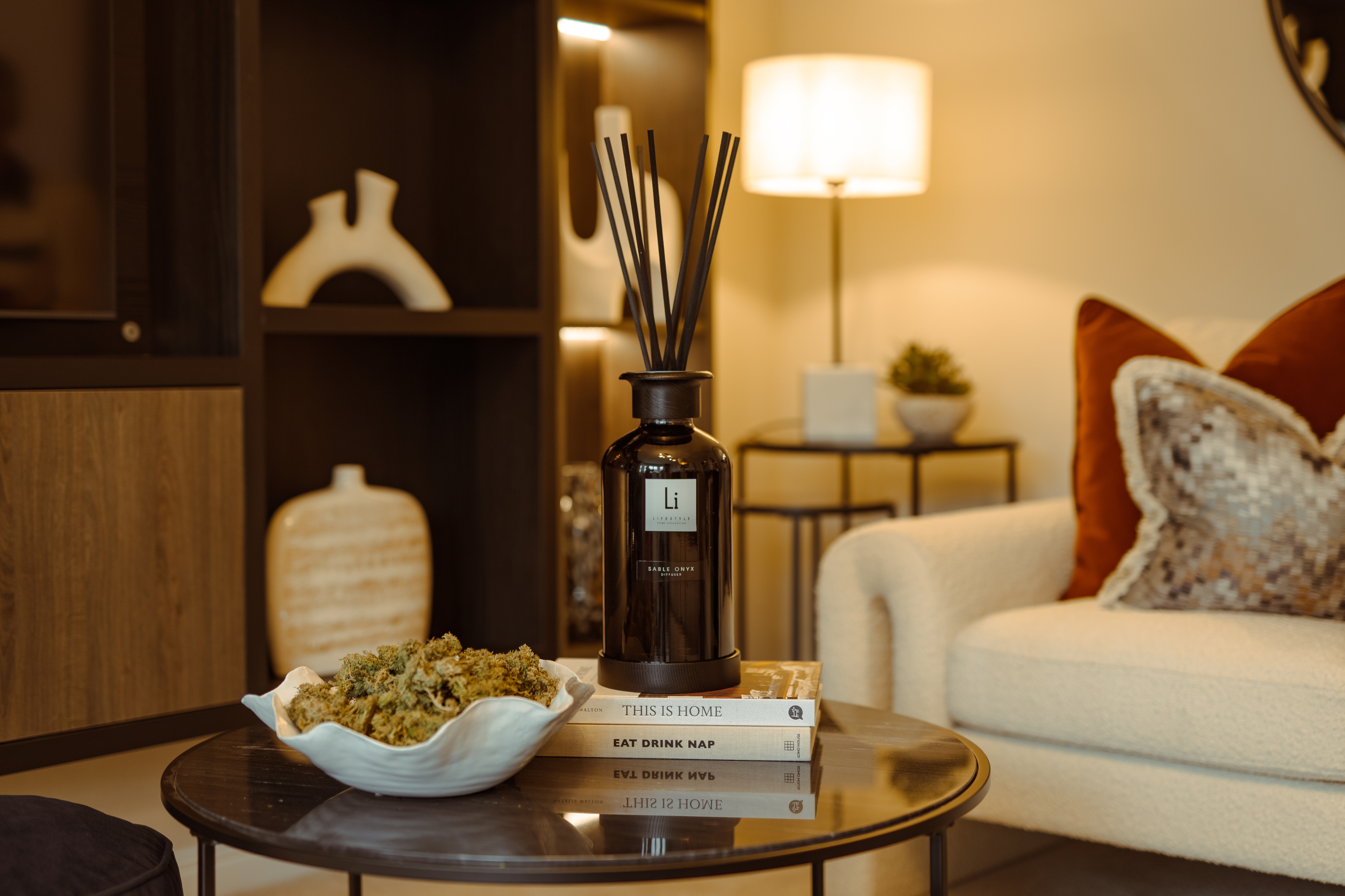 Decorative diffuser bottle on a table with a cozy living room background