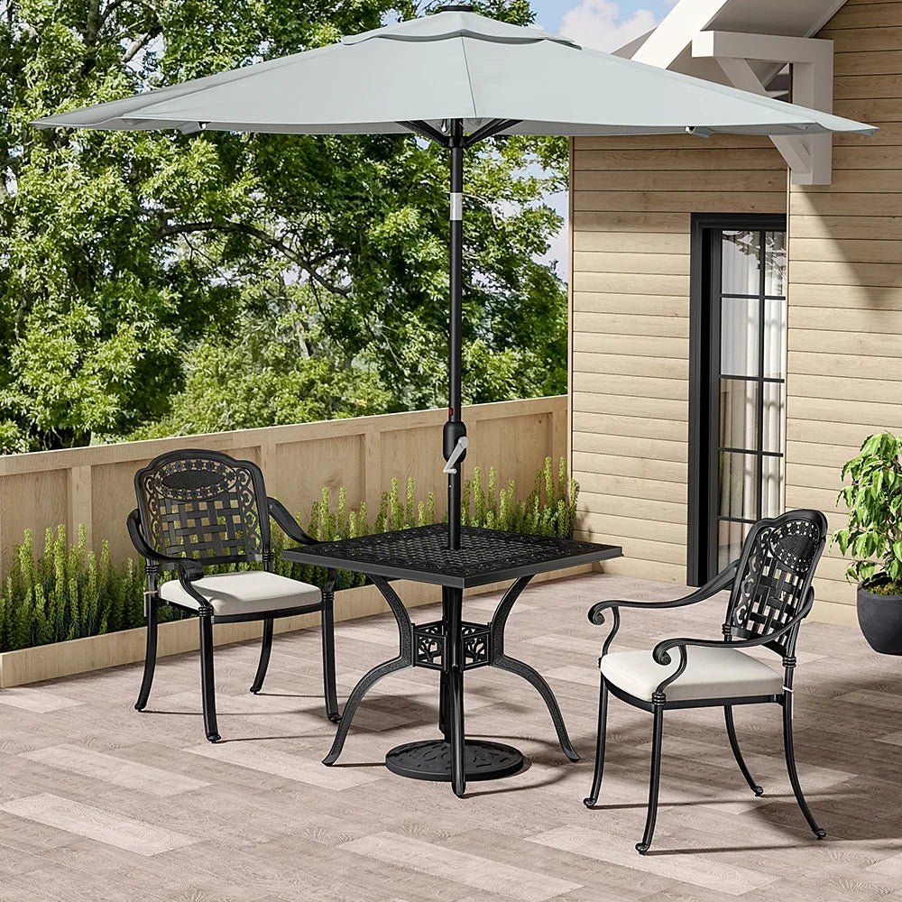 Outdoor patio set with table and chairs under a large umbrella on a wooden deck.