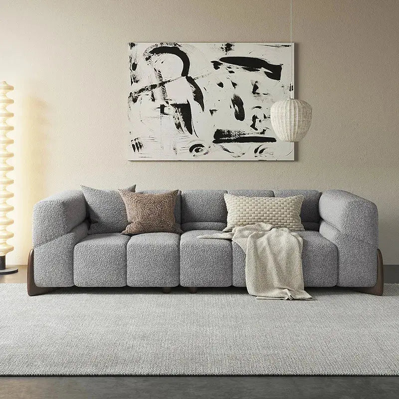 Gray sectional sofa in a living room with abstract art on the wall.