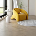 Yellow armchair in a modern room with a white side table and patterned rug.