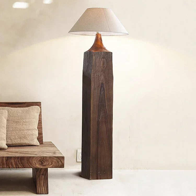 Wooden floor lamp with a beige shade in a minimalistic room.