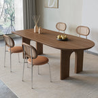 Dining room with a wooden table and chairs on a light rug.