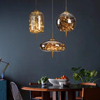 Modern dining room with glass pendant lights and a dark wall.