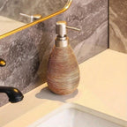 Decorative soap dispenser on a bathroom counter with marble wall in the background