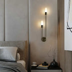 Modern bedroom with wall sconces, bed, and nightstand.
