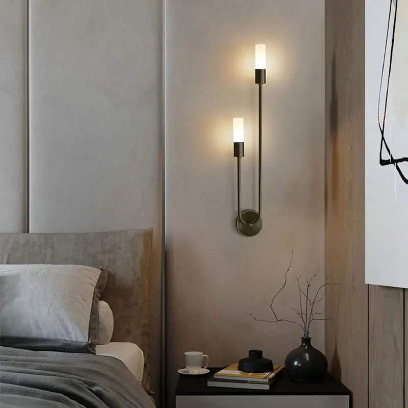 Modern bedroom with wall sconces, bed, and nightstand.