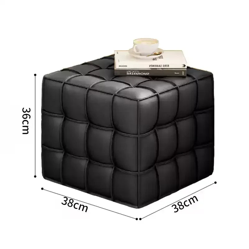 Black cube-shaped ottoman with dimensions and a book on top