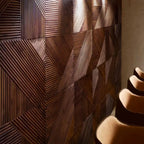 Wooden wall panel with geometric pattern and a chair partially visible.