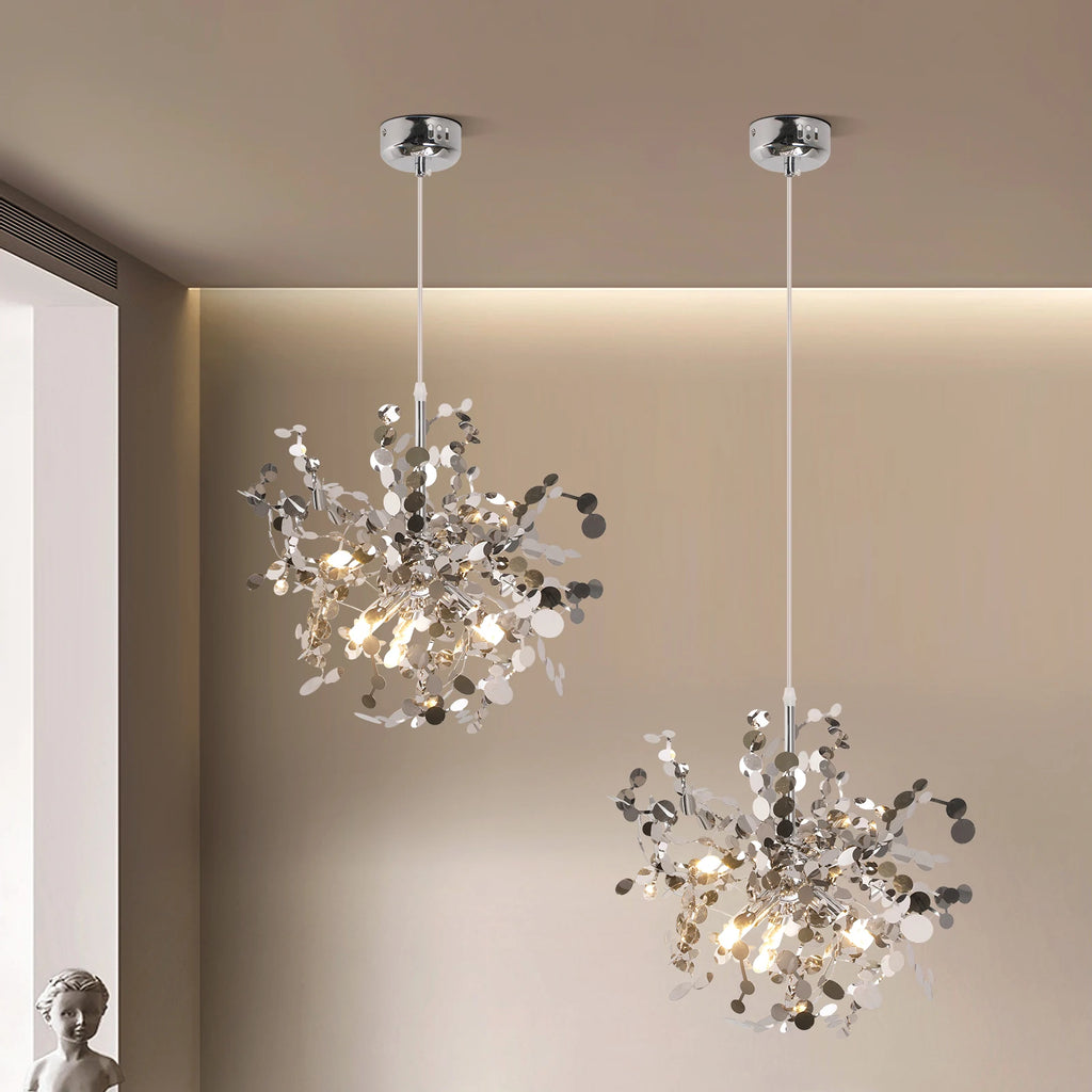 Two modern chandeliers hanging from the ceiling in a room with neutral walls.